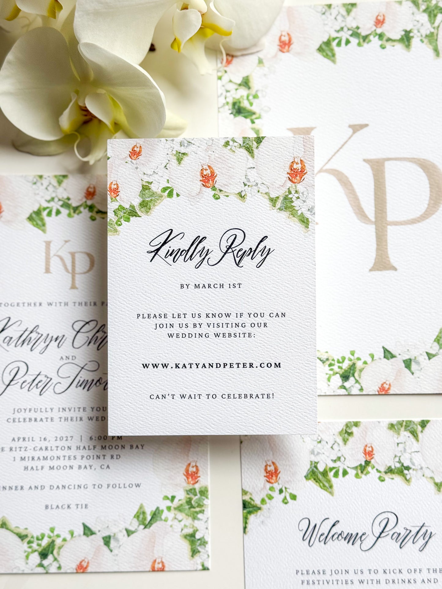Floral watercolor RSVP card, “Kindly Reply” script with green vine and orange blossoms