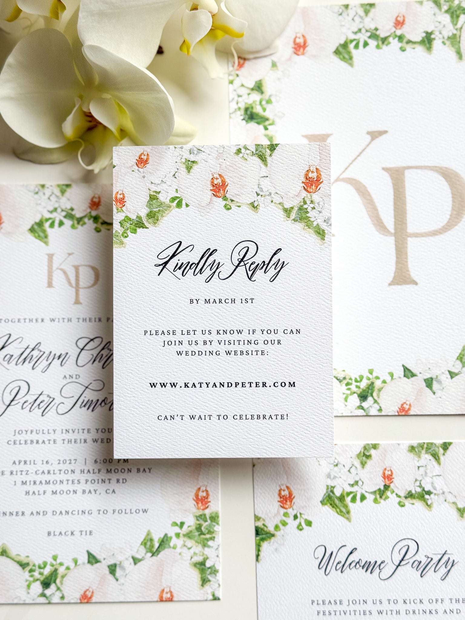 Floral watercolor RSVP card, “Kindly Reply” script with green vine and orange blossoms