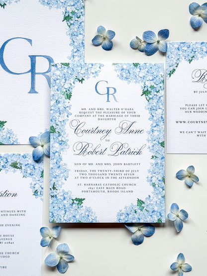 Watercolor wedding invitation with blue monogram CR, floral border, and names