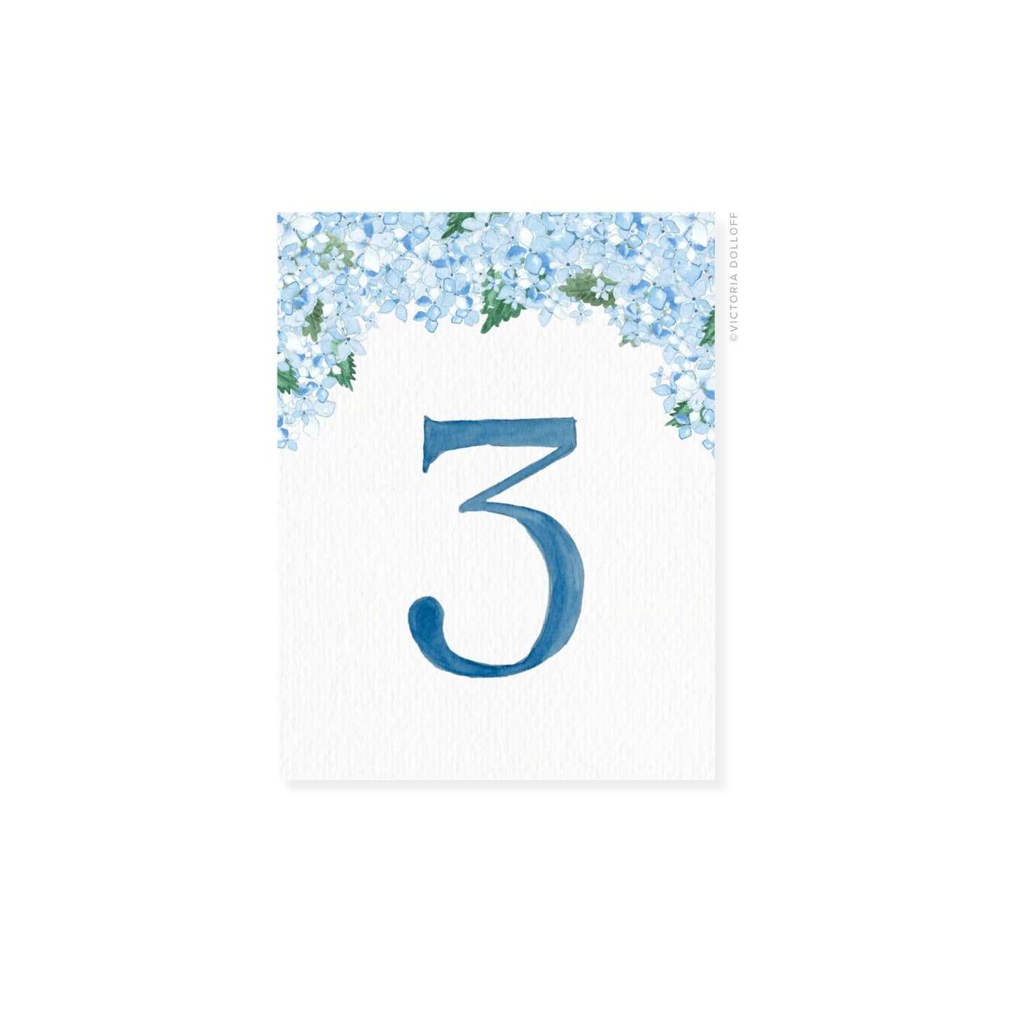 Table number 3 in ocean blue with blue floral border and greenery arch