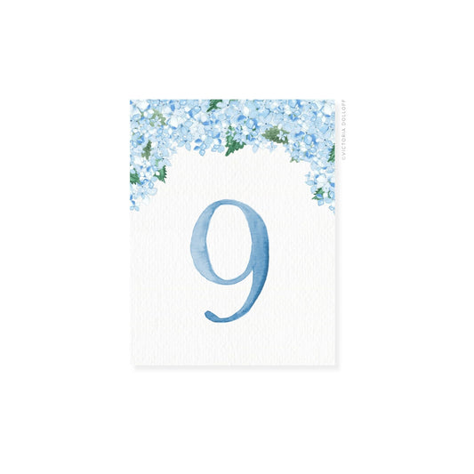 Table number 9 in blue with blue floral border and greenery arch