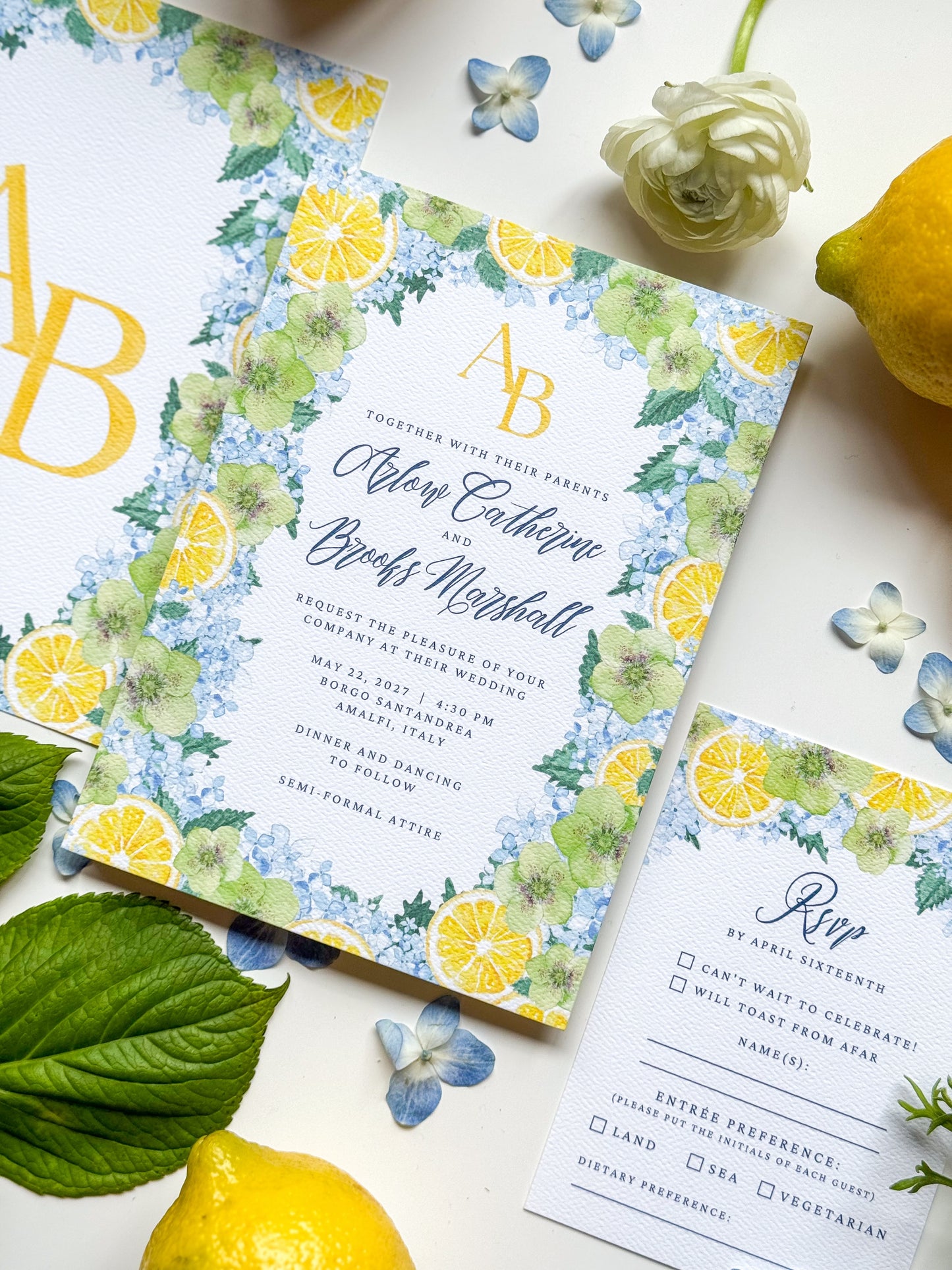 Angled watercolor wedding invitation, lemon floral border, gold initials AB and couple names