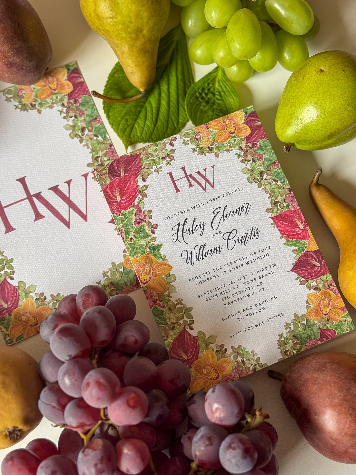 Watercolor wedding invitation with floral border, burgundy HW monogram, and wedding details