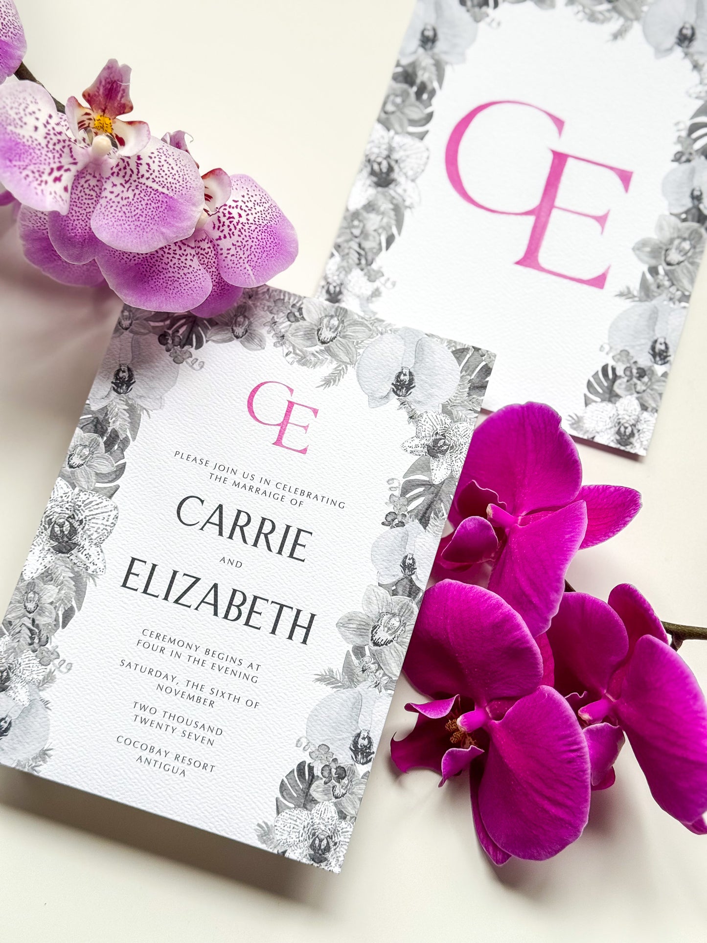 Carrie & Elizabeth watercolor wedding invitation with floral wreath border and magenta E monogram