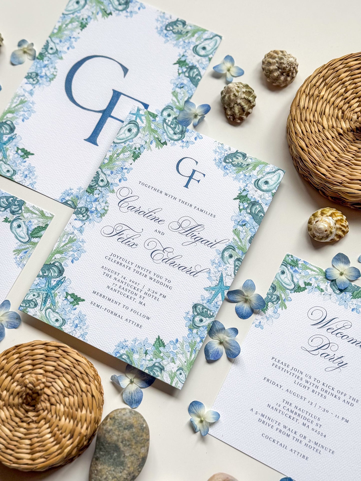 Top view wedding invite with blue monogram CF, ornate watercolor frame and guest details