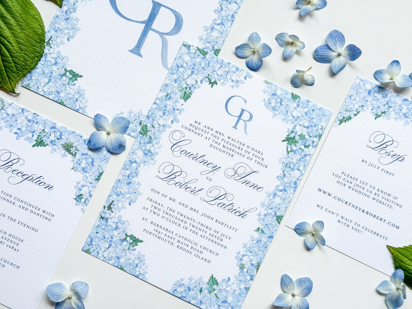 Watercolor wedding invitation with blue hydrangea border and CR monogram, blue ink text